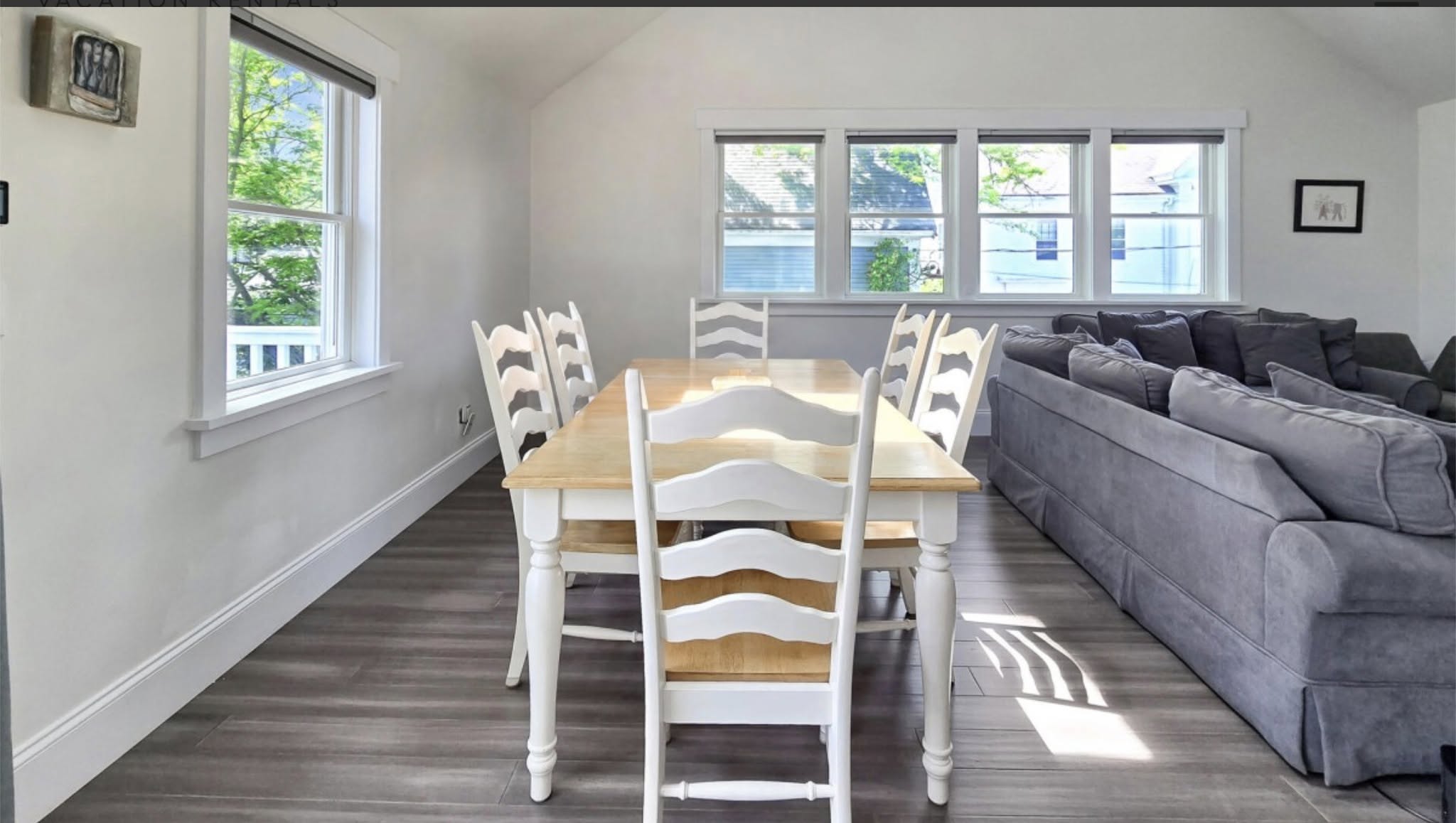 Dining table surrounded by white ladder-back chairs