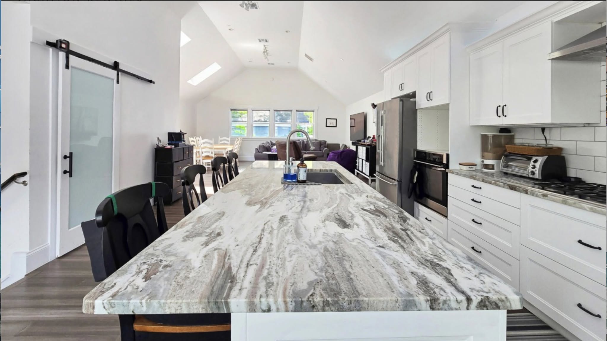 Bright open-plan kitchen with a long marble island