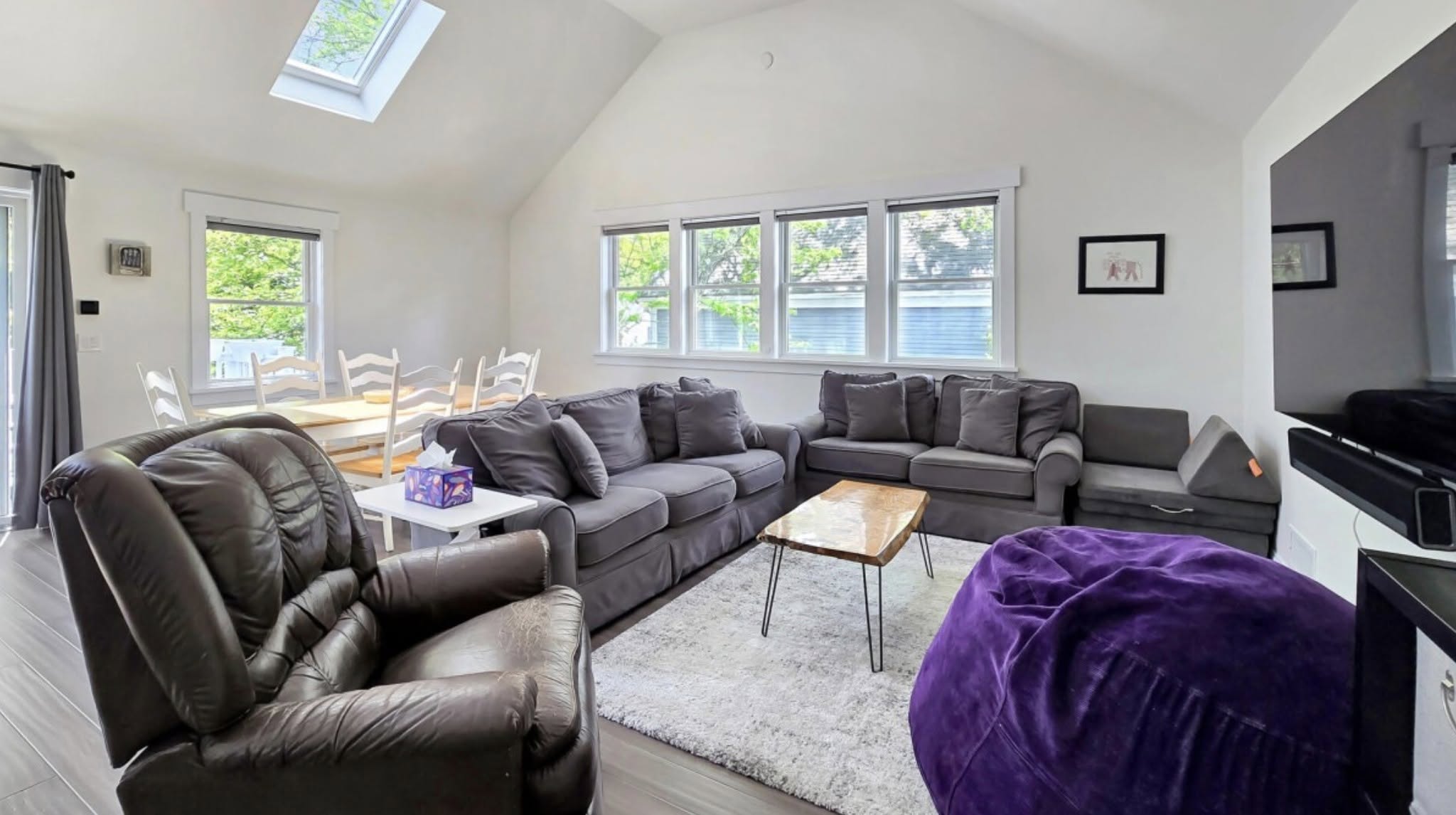 Sunlit living room with high ceilings and gray sofas