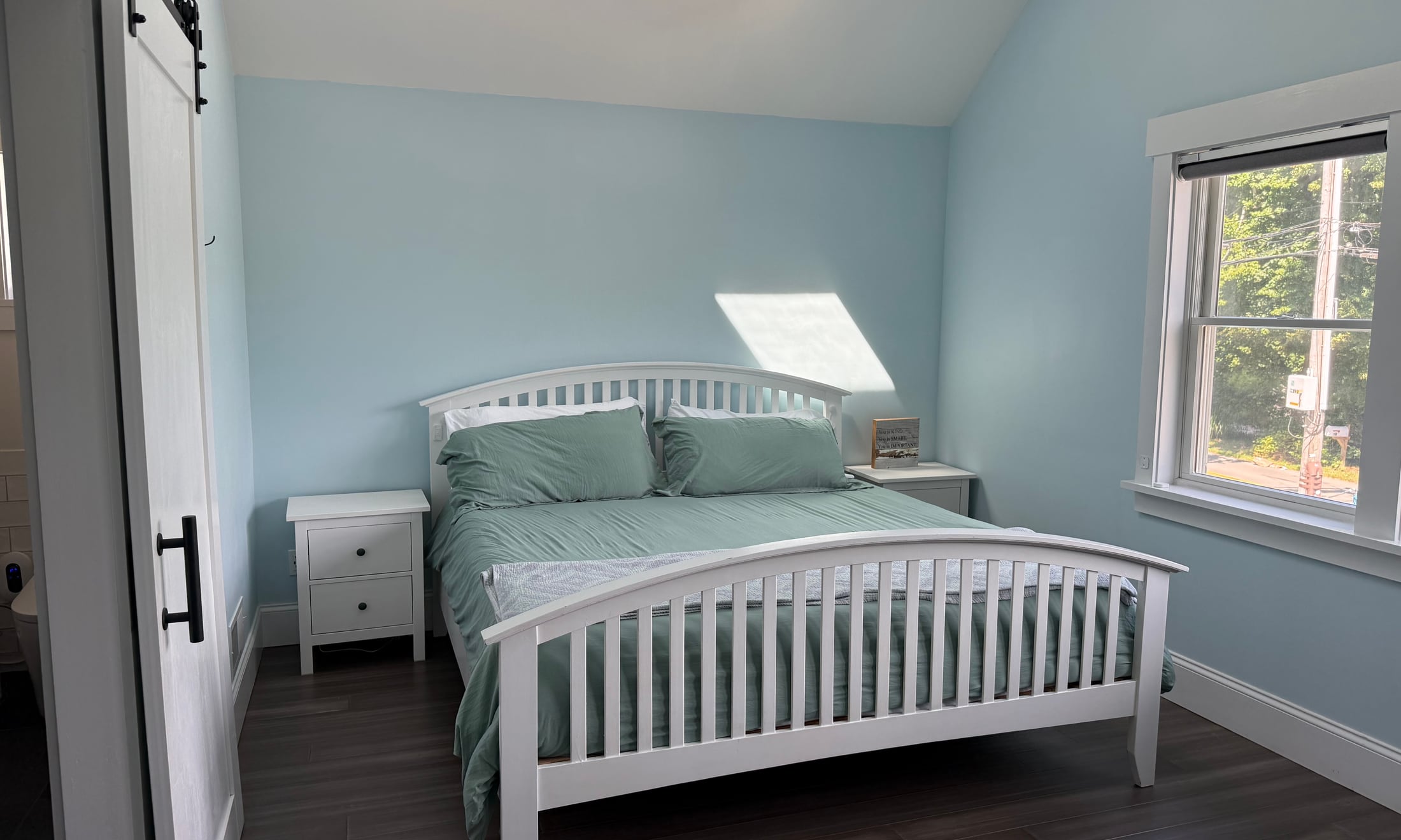 Bright primary bedroom with a large white bed and blue walls